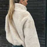 Kort jakke i imiteret pels med opretstående krave