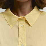 Løstsiddende gul bomuldsbluse med knapper, ideel til hverdagsbrug.