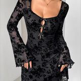 Kort kjole med lange ærmer, trykt med flockede blomster og pyntet med en åben sløjfe