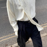 Løstsiddende bluse med polkaprikker og bånd, ideel til hverdagsbrug.