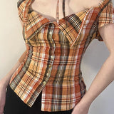 Kort ternet bluse, tætsiddende talje, bindebånd i halsen og knapper foran