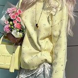 Løstsiddende bluse med en blomstret strikket pulloverhalsudskæring