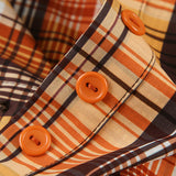 Kort ternet bluse, tætsiddende talje, bindebånd i halsen og knapper foran