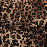 Et elegant todelt outfit bestående af en langærmet skjorte med tryk og bukser med vide ben og bælte