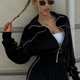 Todelt sæt med lange ærmer, en atletisk fløjlskrave og lynlåslukning.