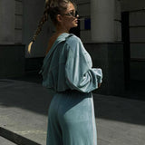 Todelt sæt med lange ærmer, en atletisk fløjlskrave og lynlåslukning.