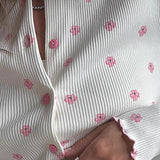 Todelt loungewear-sæt med lange ærmer og blomstrede flæser, inklusive bukser og loungewear.