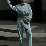 Todelt sæt med lange ærmer, en atletisk fløjlskrave og lynlåslukning.