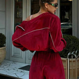 Todelt sæt med lange ærmer, en atletisk fløjlskrave og lynlåslukning.