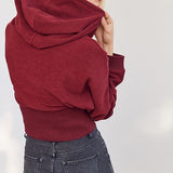 Kort hættetop, tætsiddende i taljen, afslappet stil.