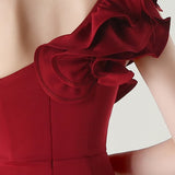 Asymmetrisk satin aftenkjole med flæser og blomster, pyntet med den ene skulder, med flæser og blomster.