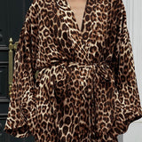 Et elegant todelt outfit bestående af en langærmet skjorte med tryk og bukser med vide ben og bælte