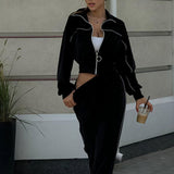 Todelt sæt med lange ærmer, en atletisk fløjlskrave og lynlåslukning.