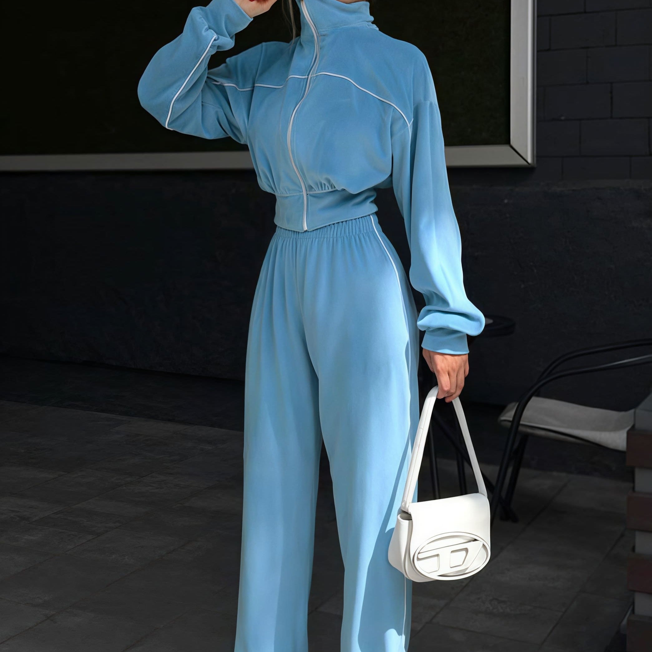 Todelt sæt med lange ærmer, en atletisk fløjlskrave og lynlåslukning.