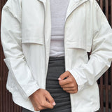 Afslappet hvid jakke med opretstående krave og lange ærmer, tætsiddende snit