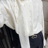 Løstsiddende bluse med polkaprikker og bånd, ideel til hverdagsbrug.