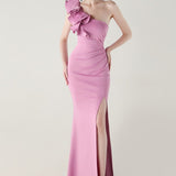 Asymmetrisk satin aftenkjole med flæser og blomster, pyntet med den ene skulder, med flæser og blomster.