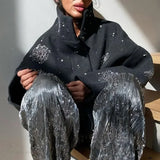 Højhalset frakke pyntet med perler og pailletter