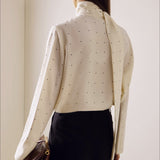 Løstsiddende bluse med polkaprikker og bånd, ideel til hverdagsbrug.