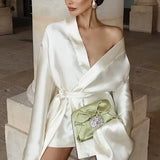 Champagnefarvet satin mini trapezkjole med bindebånd i taljen, lange ærmer og V-hals