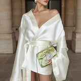 Champagnefarvet satin mini trapezkjole med bindebånd i taljen, lange ærmer og V-hals