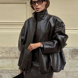 Todelt sæt: elegant jakke og nederdel i ensfarvet laklæder med opretstående krave