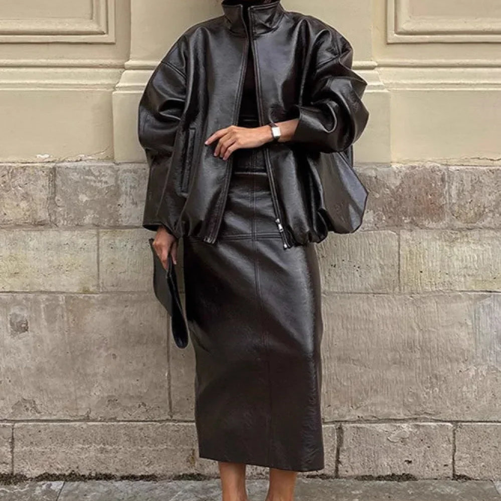 Todelt sæt: elegant jakke og nederdel i ensfarvet laklæder med opretstående krave