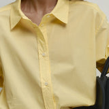 Løstsiddende gul bomuldsbluse med knapper, ideel til hverdagsbrug.