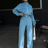 Todelt sæt med lange ærmer, en atletisk fløjlskrave og lynlåslukning.