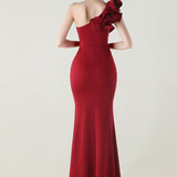 Asymmetrisk satin aftenkjole med flæser og blomster, pyntet med den ene skulder, med flæser og blomster.