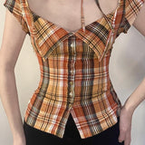 Kort ternet bluse, tætsiddende talje, bindebånd i halsen og knapper foran