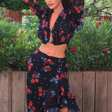 Todelt sæt bestående af en langærmet crop top og en tætsiddende nederdel med slids og flæser.