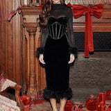 Elegant feminin midikjole med fjer, høj talje og smal pasform, udsmykket med mesh-paneler.