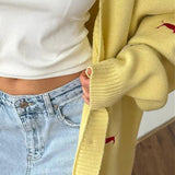 Løstsiddende cardigan i strik med knapper og gravhundbroderi