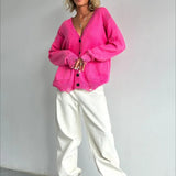 Løstsiddende cardigan i strik med dyb V-hals og knapper