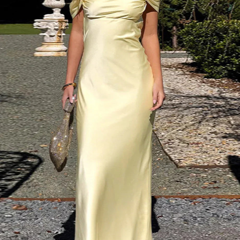 Lang satinkjole med bare stropper og åben ryg, med sløjfe og tynde stropper.