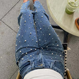 Jeans med asymmetrisk talje, crossover-top, perledetaljer og flossede lige ben