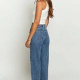 Jeans med asymmetrisk talje, crossover-top, perledetaljer og flossede lige ben