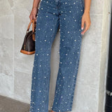 Jeans med asymmetrisk talje, crossover-top, perledetaljer og flossede lige ben