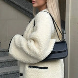 Minimalistisk ensfarvet sherpafrakke med hornknapper