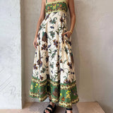 Elegant kjole med et unikt print, smocket ryg og lommer, badet i sollys