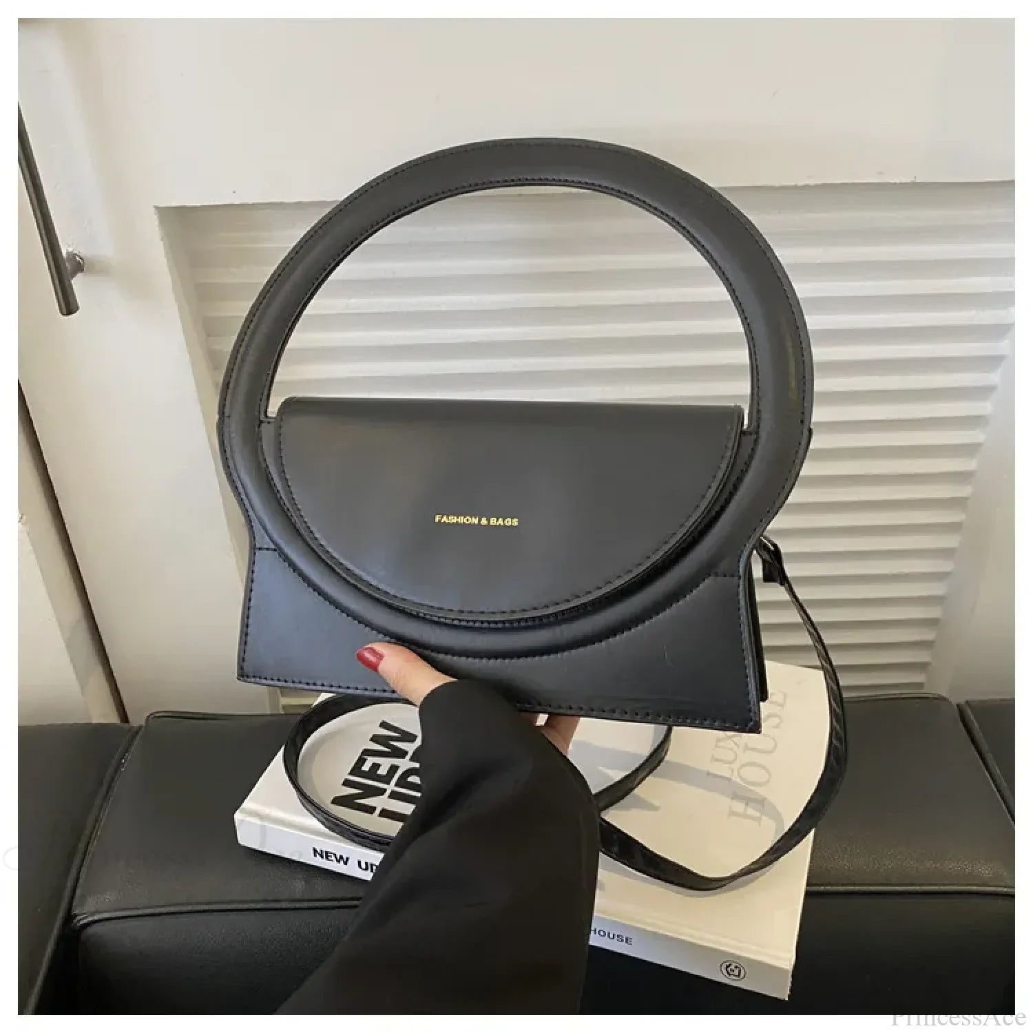 Luksuriøs skuldertaske i læder med rundt håndtag fra et eksklusivt mærke